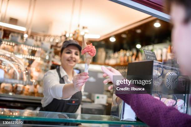 helado italiano y tienda de alimentos dulces gelateria: servir helado - gelato italiano fotografías e imágenes de stock