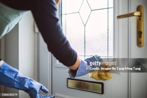 woman in household cleaning gloves cleaning the door with cloth - cleaning lady stock pictures, royalty-free photos & images