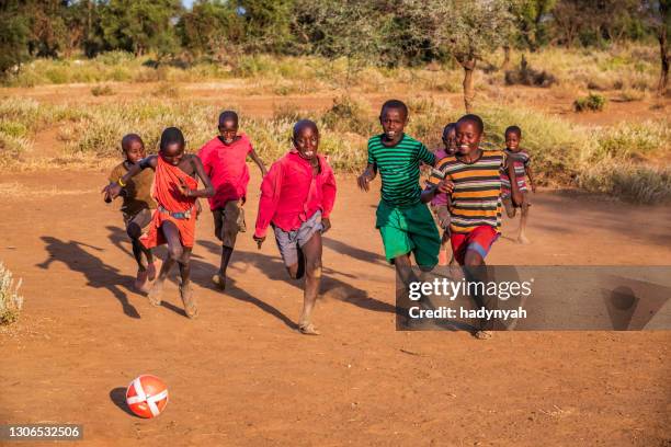 african children playing football in the village near mount kilimanjaro, east africa - barefeet soccer stock pictures, royalty-free photos & images