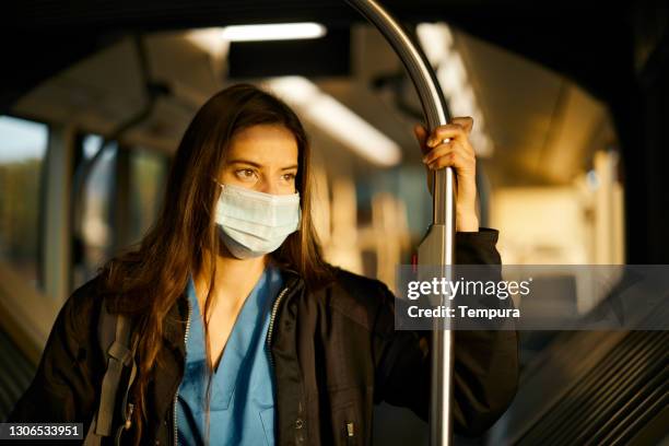 a nurse riding a bus back home. - covid commuter stock pictures, royalty-free photos & images