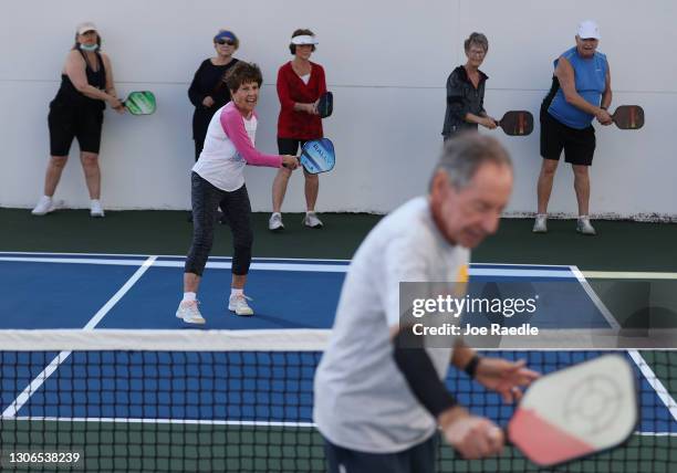 Pat Harrell and others practice their backhand as Bob Savar teaches a class in the game pickleball with a group vaccinated against COVID-19 at the...