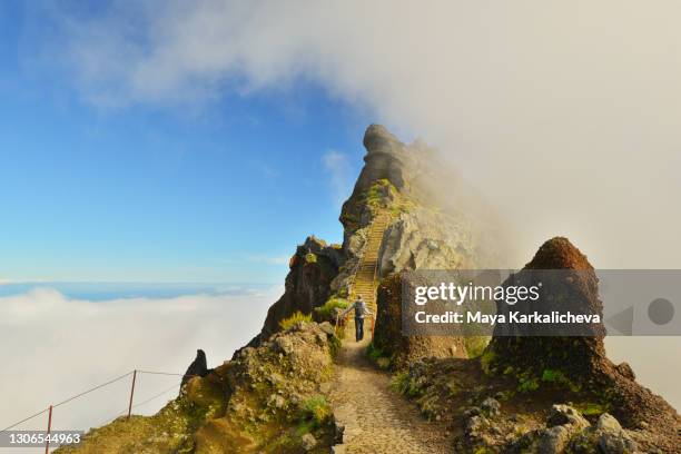 tourist hiking on amazing footpath in the mountains of madeira island, atlantic ocean, portugal - chase atlantic stock-fotos und bilder