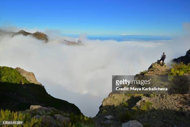 silhouette of man hiking over the clouds in madeira island mountains - pico do arieiro fotografías e imágenes de stock
