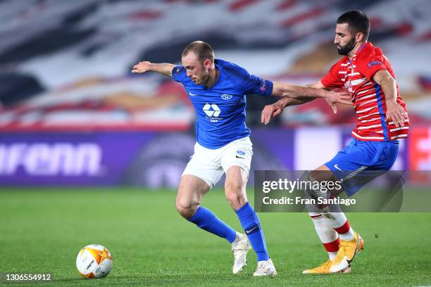 Fredrik Aursnes of Molde holds off Maxime Gonalons of Granada CF during the UEFA Europa League Round of 16 First Leg match between Granada and Molde...