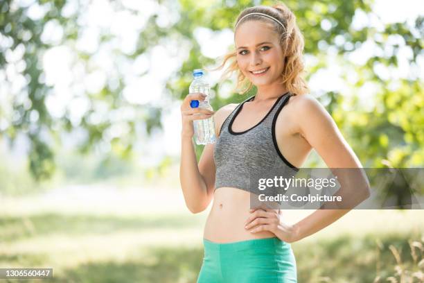 young woman exercising - break after jogging. - female navel ストックフォトと画像