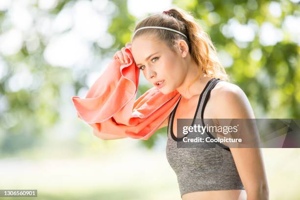 young woman exercising - break after jogging. - warm up exercise stock-fotos und bilder