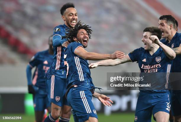 Mohamed Elneny of Arsenal celebrates with team mates Kieran Tierney and Pierre-Emerick Aubameyang after scoring their side's third goal during the...