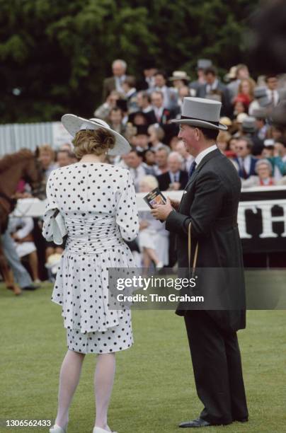 British Royal Diana, Princess of Wales , wearing a dress by Victor Edelstein and hat by Frederick Fox, standing with an unspecified man in morning...