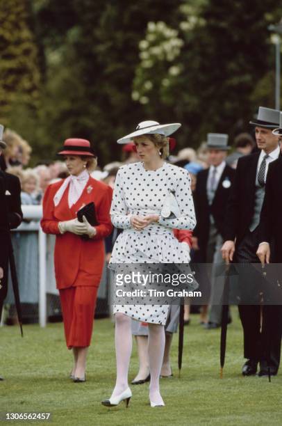 British Royals Princess Alexandra, wearing a red suit, and Diana, Princess of Wales , wearing a dress by Victor Edelstein and hat by Frederick Fox,...