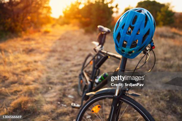 close-up of a bicycle and cycling helmet in nature - cycling helmet stock pictures, royalty-free photos & images