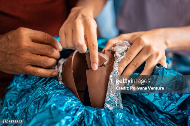 primer plano de las personas que comen huevo de pascua - huevo de pascua de chocolate fotografías e imágenes de stock