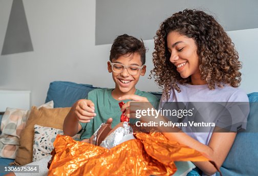 Siblings eating easter egg on sofa Siblings eating easter egg on sofa