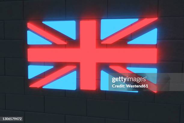 illuminated british flag on black brick wall - union jack stock pictures, royalty-free photos & images