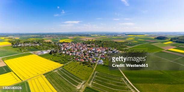 germany, hesse, munzenberg, helicopter panorama of countryside village and surrounding fields in summer - hesse germany stock-fotos und bilder