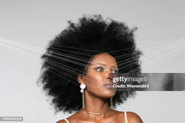 afro woman with facial recognition laser beam while looking away against white background - facial recognition technology stock-fotos und bilder