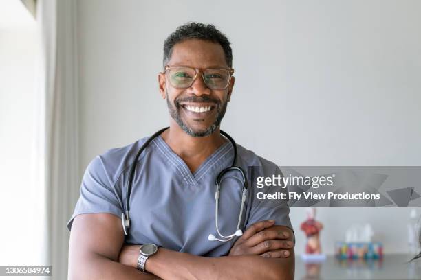 portrait of a handsome male nurse - doctor headshot stock pictures, royalty-free photos & images