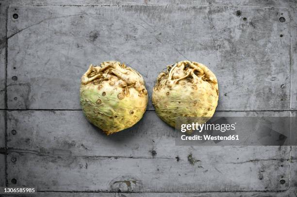 halved celeriac lying on gray wooden surface - celeriac stock pictures, royalty-free photos & images