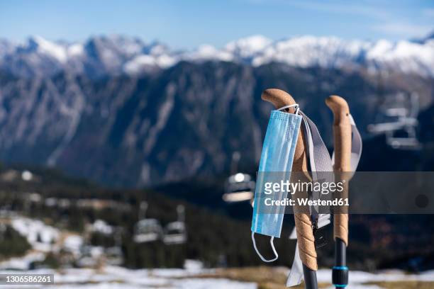face mask hanging on ski pole during covid-19 - ski pole stock-fotos und bilder