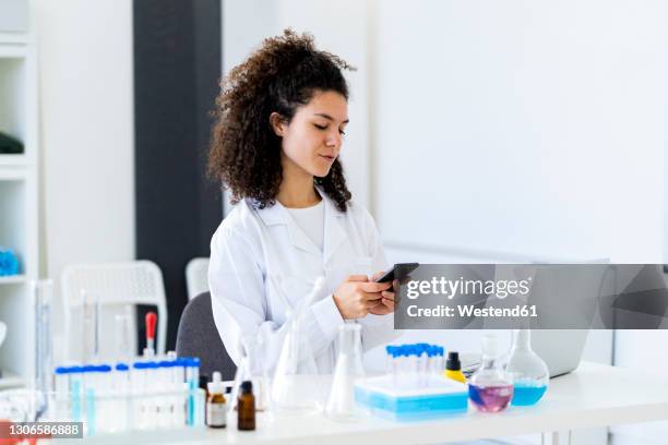 young female researcher using smart phone at clinic - stem cells human stock-fotos und bilder