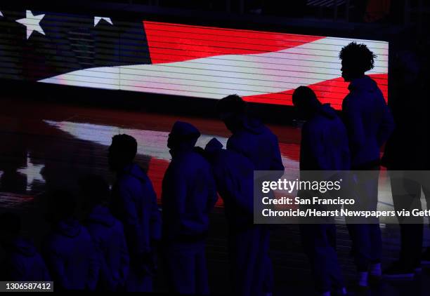 James Wiseman , stands with teammates listening to the national anthem before a game between the Golden State Warriors and Sacramento Kings at Chase...
