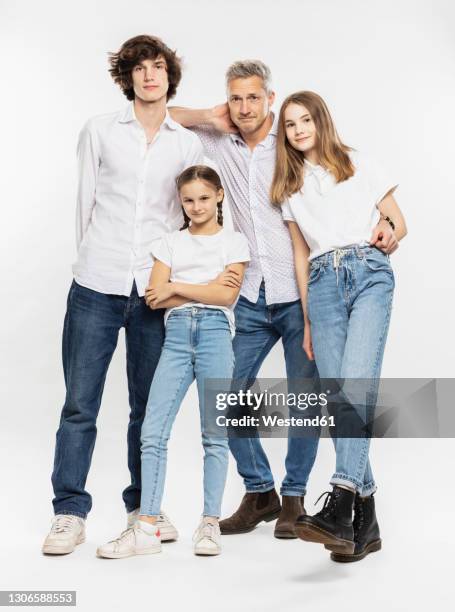 father and children standing together against white background - girl standing crossed arms studio stock pictures, royalty-free photos & images