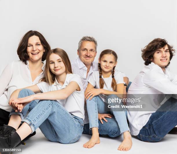 family with children sitting against white background - fünf personen stock-fotos und bilder