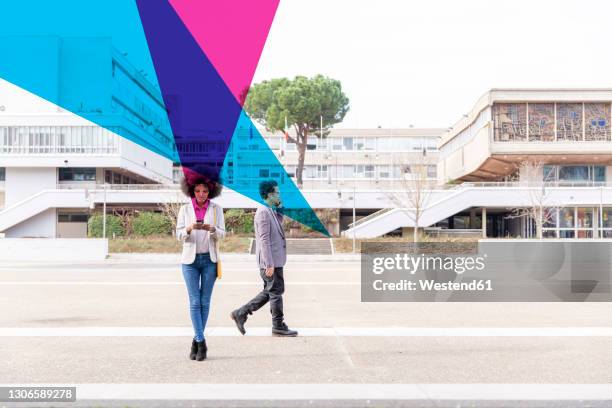 graphic visualization of facial recognition effects covering man and woman using smart phones outdoors - triangle day 2 stock-fotos und bilder