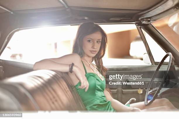 young woman staring while sitting in vintage car - vintage car interior stock pictures, royalty-free photos & images