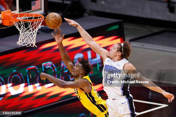 Jimmy Butler of the Miami Heat is fouled by Aaron Gordon of the Orlando Magic during the third quarter at American Airlines Arena on March 11, 2021...