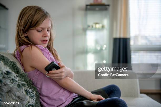 young girl checking her blood sugar level - childhood diabetes stock pictures, royalty-free photos & images