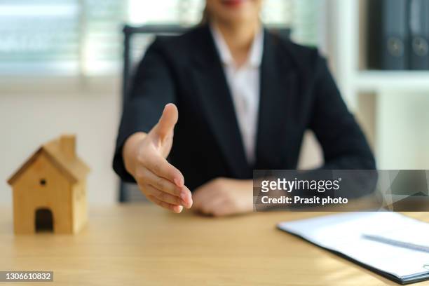 real estate broker businesswoman ready to shakehand to seal a deal with her customer signing a contract: real estate, home loan and insurance concept. - real estate broker stock-fotos und bilder