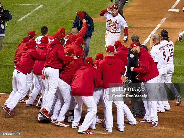 David Freese is greeted by his teammates after hitting a walk-off home run in the bottom of the eleventh inning during Game Six of the 2011 World...