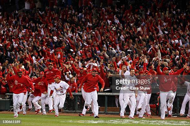 The St. Louis Cardinals bench runs on the field after David Freese hits a walk off solo home run in the 11th inning to win Game Six of the MLB World...