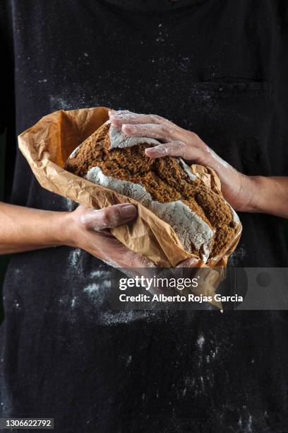 hands of baker with bread - bakery apron stock pictures, royalty-free photos & images