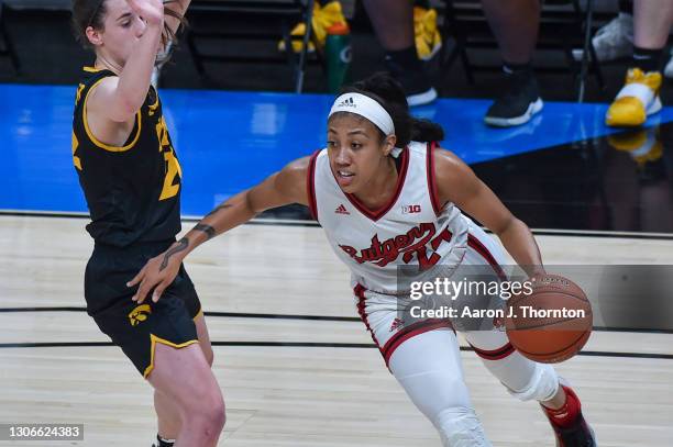 Arella Guirantes of the Rutgers Scarlet Knights attempts to drive to the basket while being guarded by Caitlin Clark of the Iowa Hawkeyes during the...