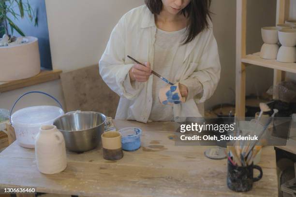 weibliche ceramistin arbeitet in ihrem studio - emaille stock-fotos und bilder