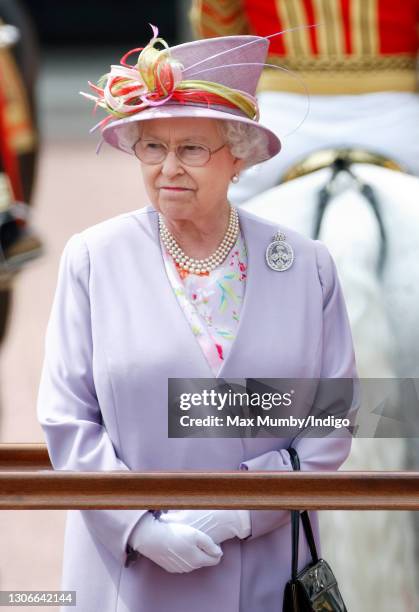 Queen Elizabeth II takes the salute whilst standing on a dais outside Buckingham Palace during the annual Trooping the Colour Parade on June 12, 2010...