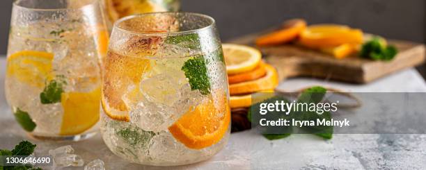 fresh cocktail with crushed ice, mint leaves and divers oranges. summer cold drink concept with copy space, banner - tangerine martini stock pictures, royalty-free photos & images