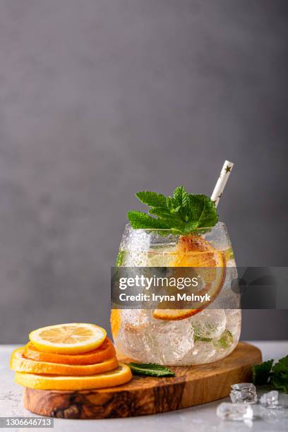 fresh lemonade cocktail with crushed ice, mint leaves and divers oranges. summer cold drink concept with copy space - tangerine martini stock pictures, royalty-free photos & images