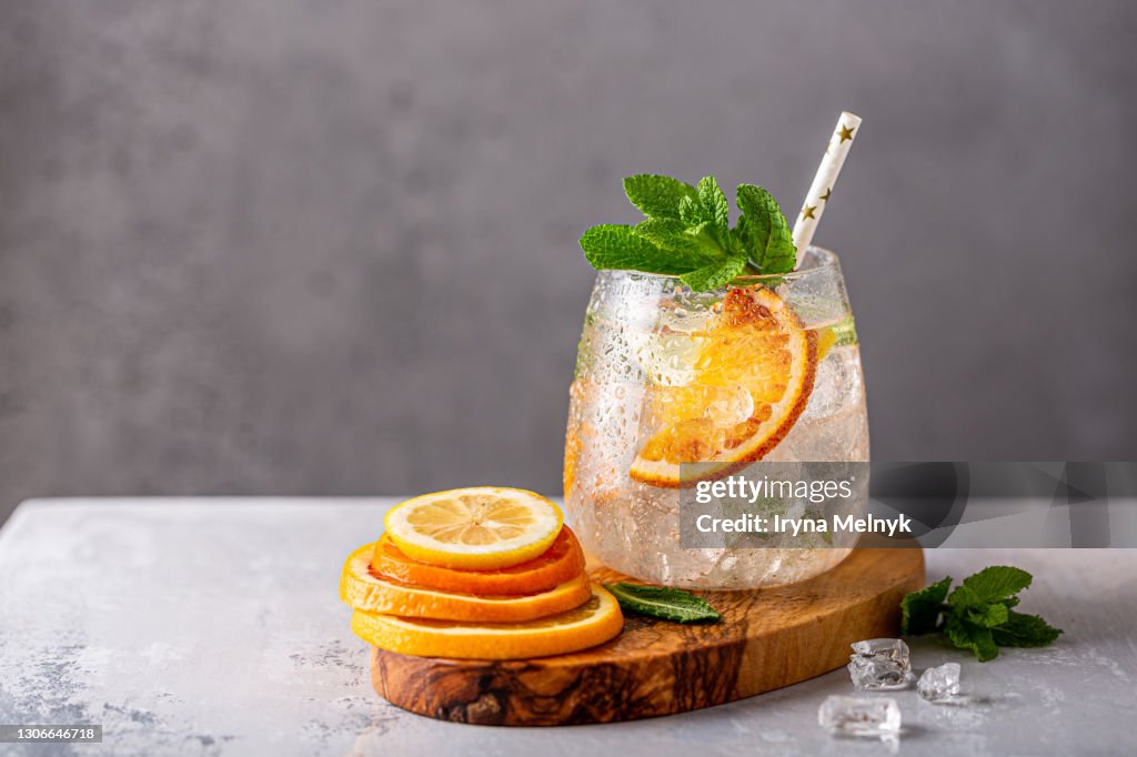 Fresh lemonade cocktail with crushed ice, mint leaves and divers oranges. Summer cold drink concept with copy space