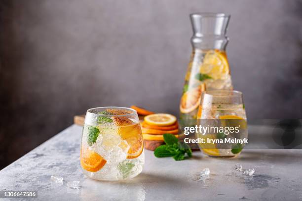 fresh cocktail with crushed ice, mint leaves and divers oranges. summer cold drink concept with copy space - tangerine martini stock pictures, royalty-free photos & images