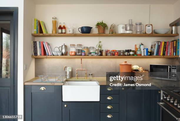 shaker style kitchen with belfast sink and clutter on shelves. - microwave mess stock pictures, royalty-free photos & images