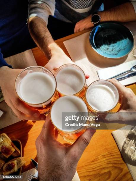 top view group of friends toast with glasses of beer - friends toasting above table stock-fotos und bilder