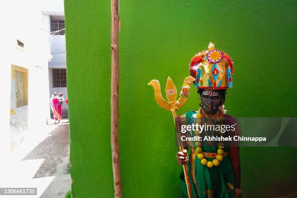 Girl dressed in the style of a Hindu goddess poses for a photo in an alleyway during Maha Shivaratri on March 12, 2021 in Kaveripattinam, India. Maha...