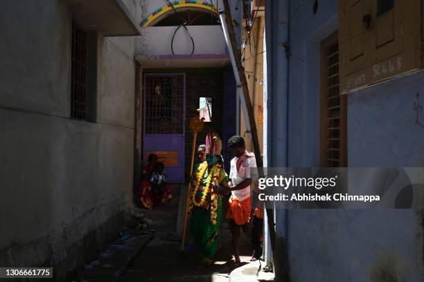 Girl dressed as Hindu goddess is helped through an alleyway during Maha Shivararti celebrations on March 12, 2021 in Kaveripattinam, India. Maha...