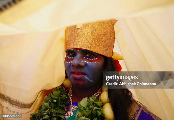 Woman dressed in the style of a Hindu goddess keeps her face covered for a ritual during Maha Shivaratri celebrations on March 12, 2021 in...
