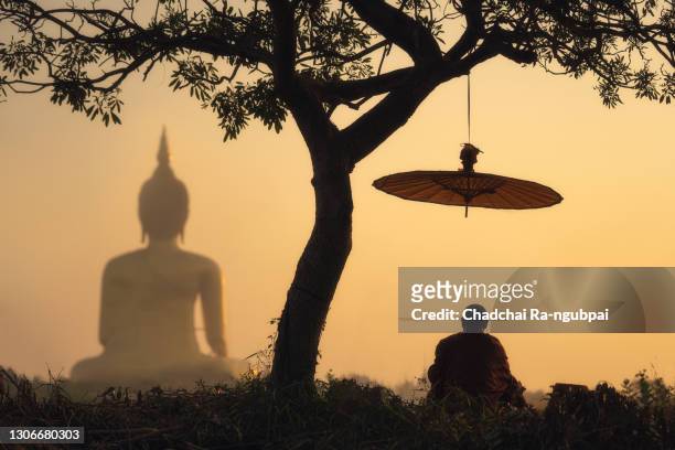 monk maditation with big buddha of wat muang ang thong province thailand. - buddha stock-fotos und bilder