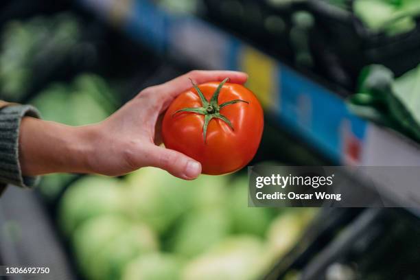 shopping for fresh vegetables in supermarket - tomate fotografías e imágenes de stock