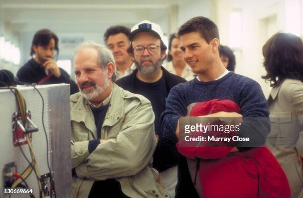 Director Brian De Palma and actor Tom Cruise watching the rushes on the set of the film 'Mission: Impossible', 1996.