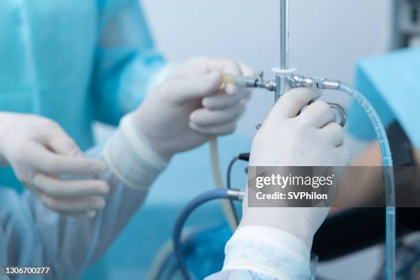 surgeon's hands work with medical instrument for hysteroscopy. - gyroscope stock pictures, royalty-free photos & images